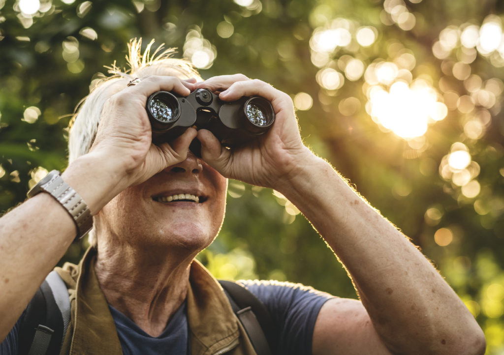 Man watching birds through binoculars