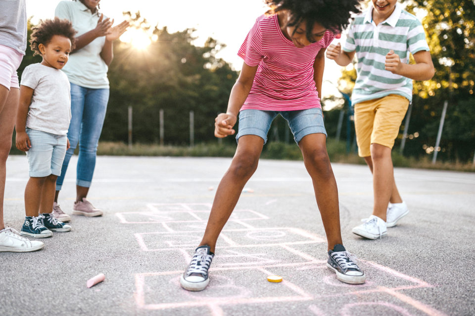 Family playing hopscotch outside